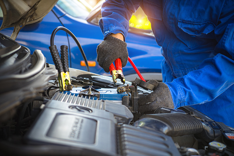 Certified GMC technician servicing car battery and engine components